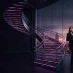 Profesional en una oficina futurista iluminada en magenta y violeta con espacio para titular.